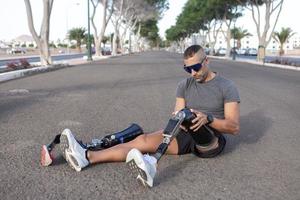 Young male amputee taking off artificial leg changing for running photo