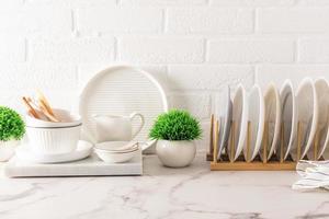 hermoso fondo de cocina para el diseño. varios utensilios modernos sobre el fondo de una pared de ladrillo blanco y plantas verdes interiores en macetas. foto