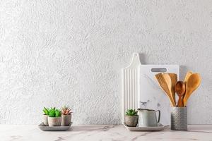 diseño moderno de la encimera de la cocina en un estilo minimalista. hermosos utensilios de cocina en una encimera contra una pared con textura gris. un espacio de copia.