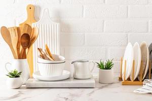 front view of the marble white countertop with various kitchen utensils made of natural materials. ecologically clean house. zero waste. photo