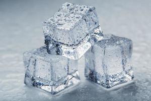 Ice cubes in the form of a pyramid with water drops close - up in macro on a white background. photo