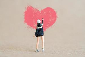 Artist holding dispenser and spraying with red heart shapes, Valentine day concept photo
