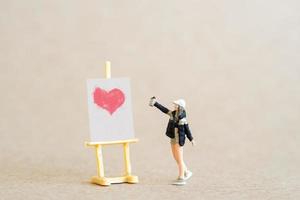 Artist holding dispenser and spraying with red heart shapes, Valentine day concept photo