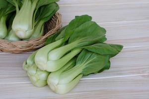 bok choy fresco o pak choi o repollo chino sobre fondo de madera y en una cesta para cocinar. concepto, vegetales orgánicos. comida sana. altas fibras y vitaminas. foto