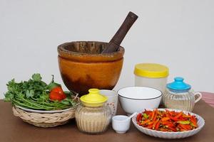 Preparing food ingredients and equipment for cooking, pestle and mortar, vegetables, jars and cups.Concept, Thai traditional cooking style. photo