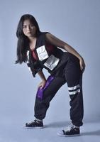 photo of a teenage girl with sporty outfit dancing. photo of a female urban dancer action pose on white background.