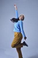 photo of a teenage girl with sporty outfit dancing. photo of a female urban dancer action pose on white background.