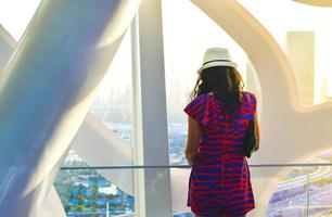 Dubai, UAE, 2022- caucasian tourist in famous Frame landmark enjoy panorama of city skyline. Visit UAE holiday travel destinations in Dubai concept photo