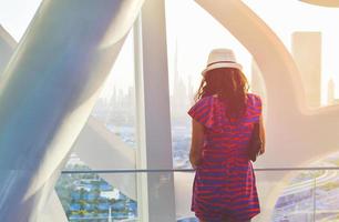 Dubai, UAE, 2022 - caucasian tourist in famous Frame landmark enjoy panorama of city skyline. Visit UAE holiday travel destinations in Dubai concept photo