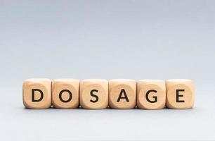 Dosage word on wooden blocks on gray background. Copy space photo