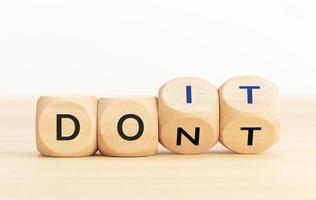 From Dont to Do it concept.Text on wooden blocks and changing dices photo