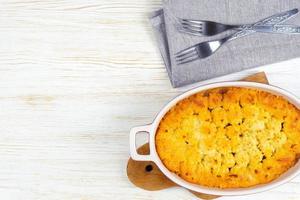 Shepherd's Pie or Cottage Pie, traditional British dish on white wooden background photo