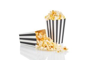 Two blakc white striped carton buckets with tasty cheese popcorn, isolated on white background photo