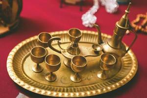 Golden tea set with tray tea pot and glasses in the antique shop vintage style photo