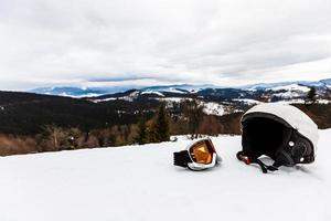 Ski helmet and ski goggles lie in the snow photo