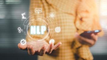 NLP natural language processing cognitive computing technology concept, Business person hand holding VR screen NLP icon on office desk, AI Artificial intelligence. photo