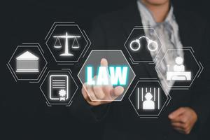 Justice and law concept, Businesswoman hand touching law icon on virtual screen on drak background. photo