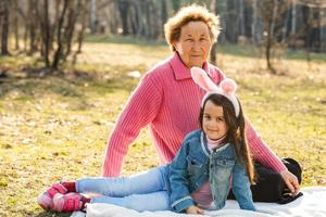 Easter concept. Happy little girl and her grandmother coloring eggs for Easter photo