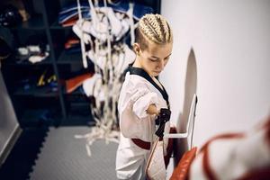 Taekwondo fighter with para-ability getting ready for sports training in dressing room. photo