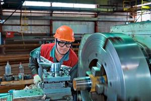 astana, kazajstán, 24 de junio de 2021- trabajador en una máquina corta hilos en una tubería. foto