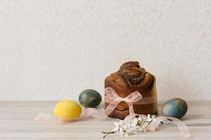 Easter composition with orthodox sweet bread, kulich and eggs on beige background. Easter holidays breakfast concept. photo