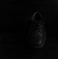 Pair of black male classic shoes on black background. Dusty shoes photo