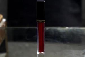 Red lipstick isolated on black background photo