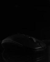 Black computer mouse on black background photo
