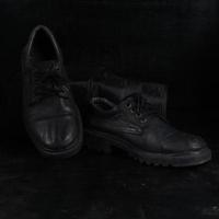 Pair of black male classic shoes on black background. Dusty shoes photo