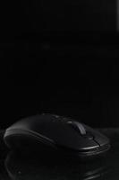 Black computer mouse on black background photo