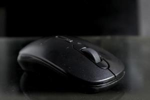 Black computer mouse on black background photo