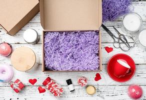 Seasonal opened gift box for valentine day with candle, red cup and heart shape sweets photo