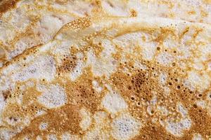 Pancake surface texture and pattern. Close-up of thin hot pancakes in a plate. Traditional rustic food. Graphic resource. photo