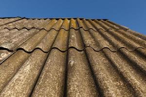 texture of wavy old roofing slate. Full frame background. Blue sky photo