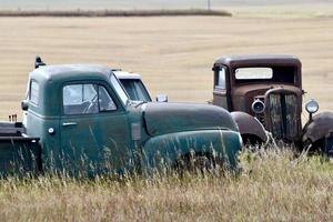 old pickup trucks in a field photo