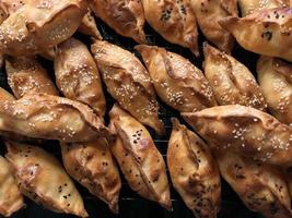 bunch of fried delicious pies sprinkled with cumin, sesame seeds photo