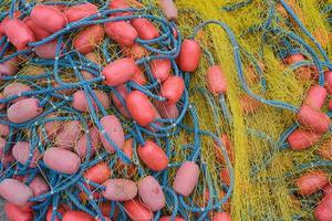 Fishing net with ropes and floats is drying on the pier, close-up, selective focus photo