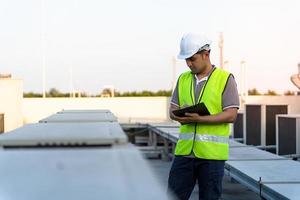 ingenieros de fábrica caminando y revisando el sistema de enfriamiento de la fábrica. El capataz registra el estado del compresor antes del mantenimiento según el plan de mantenimiento. foto