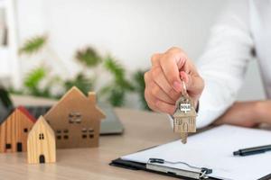 selling home. House sales agents send home keys to customers. The merchant closes the deal successfully after the customer agrees to sign the contract. photo