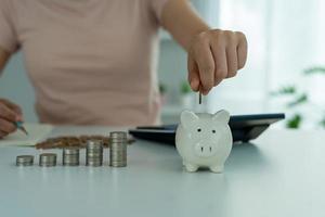 Piggy bank with a pile of coins. Women owe credit cards are calculating all expenses and liabilities. debt concept photo