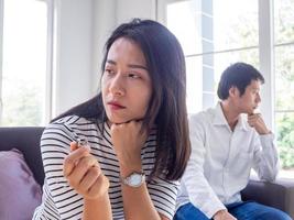 las mujeres asiáticas lloran y se irritan por el comportamiento de su marido. después de una discusión y causando dolor en el corazón. enojado y sin entenderse, resultando en divorcio foto