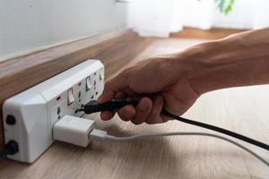 Ahorre electricidad, ahorro de energía y protección del medio ambiente. el dedo del hombre presiona el botón para apagar la luz. uso economico de la electricidad foto