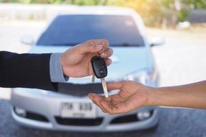 Car salesmen send keys to new car owners. Used car sales agency, car rental photo