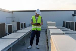 ingenieros de fábrica caminando y revisando el sistema de enfriamiento de la fábrica. El capataz registra el estado del compresor antes del mantenimiento según el plan de mantenimiento. foto