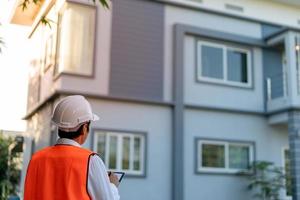 Inspector or engineer is checking and inspecting the building or house by using checklist. Engineers and architects work on building the house before handing it over to the landlord. photo