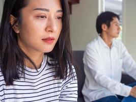 Asian couple is sad and anxious not speak after quarrel. The upset wife feels angry, thinking of problems in the relationship. Worried about the future of divorce with the husband is not interested. photo