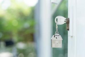 House keys on the keyhole. The house is sold. Property concept photo