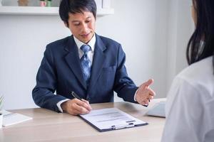 The employer is reading the resume during a conversation about the job applicant's resume. The employer in the suit is conducting a job interview, hiring manager resources and recruitment ideas. photo