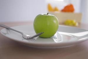 Green apples in a plate. Eating for good health and weight loss. diet concept photo