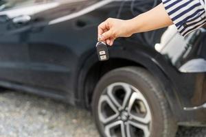 un empleado de una empresa de alquiler de coches turísticos presenta las llaves del coche con una prueba de conducción. buen servicio antes de acordar un contrato de arrendamiento o compra. foto